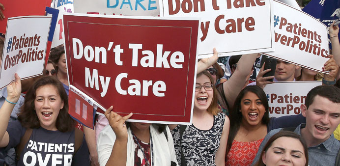 People celebrate in front of the US Supreme Court after the ruling was announced on the Affordable Care Act yesterday in Washington, DC.