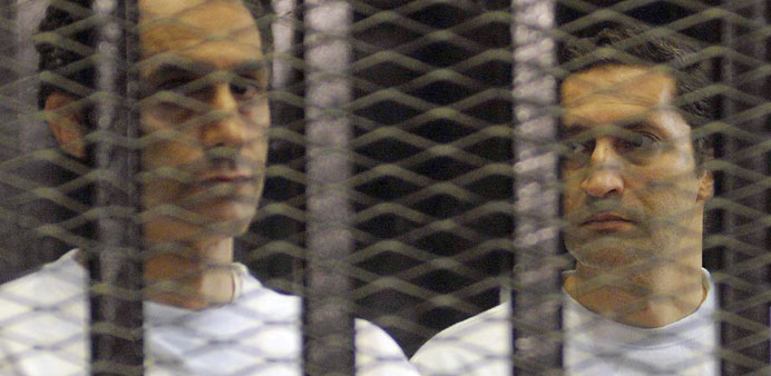 A file picture taken on June 2, 2012, shows Alaa and Gamal Mubarak standing inside a cage in a courtroom during their verdict hearing in Cairo.