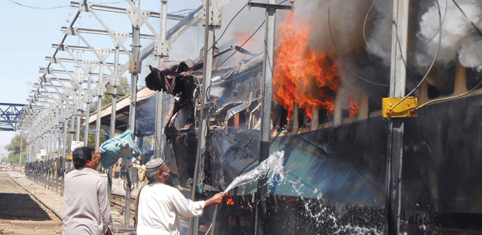 A Pakistani railway official extinguishes fire after a bomb blast on a train at the Sibi railway station some 160km south of its destination Quetta ye