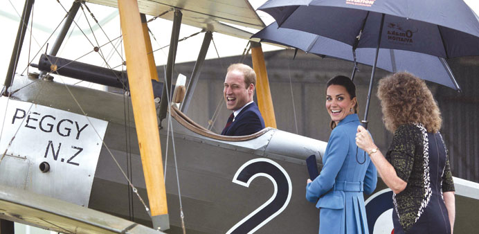 Britainu2019s Prince William sits in the cockpit of an old Sopworth Pup single-seat biplane as his wife Catherine looks on during a visit to the Omaka Avi