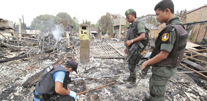 Thai security personnel inspect the site of a bomb attack, in the southern Narathiwat province yesterday.