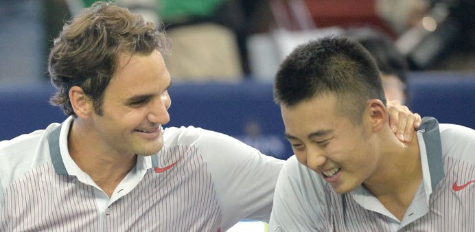 Roger Federer (left) and Ze Zhang celebrate their first round doubles win against Kevin Anderson and Dmitry Tursunov at the Shanghai Masters yesterday