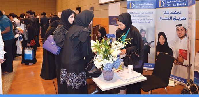 Doha Bank representatives attending to job seekers during the career fair at Education City.