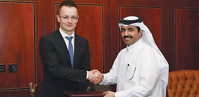 HE al-Sada and Peter Szijjarto exchange documents after signing the MoU in Doha yesterday.