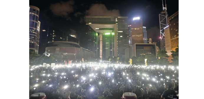 Protesters wave their mobile phones and other electronic devices as they take part in a pro-democracy rally next to the Hong Kong government complex.