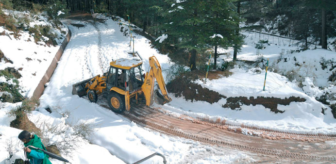 A bulldozer clears snow from a road near the village of Naddi, about 12km from Dharamsala in Himachal Pradesh yesterday.
