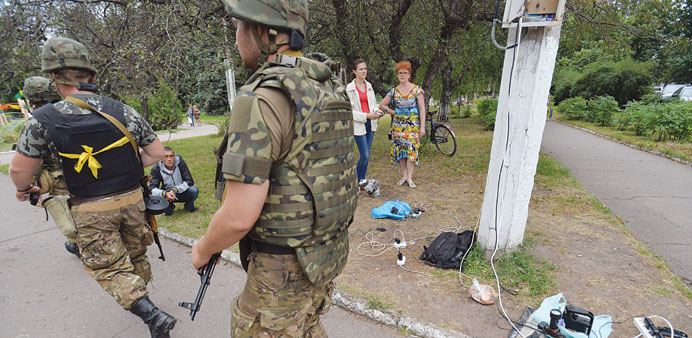    Ukrainian servicemen patrol streets of Sloviansk as residents charge their mobile phones due to lack of electricity in their homes.