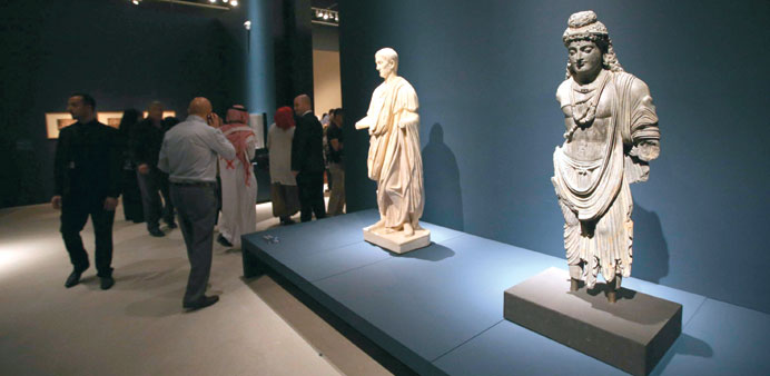 Journalists attend a media preview next to sculptures displayed at the Louvre Abu Dhabi yesterday.