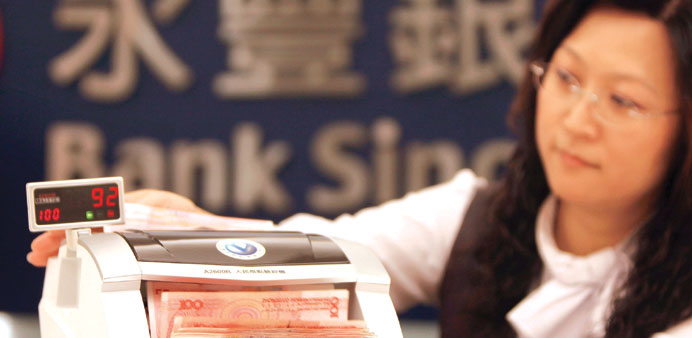 An employee counts yuan banknotes in a bank branch in Beijing.  China Cinda Asset Managementu2019s drive to crank profit out of bad loans has come at a co