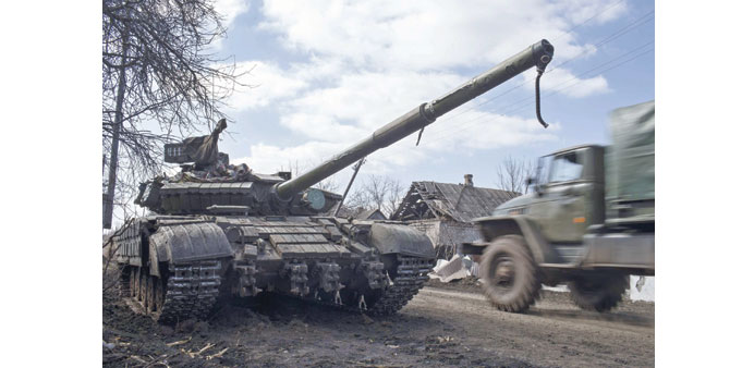 A truck passes by a pro-Russian rebelu2019s tank with a gas mask placed on its barrel in the village of Molochnoye, northeast of Donetsk.