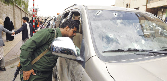 A soldier inspects a bullet-scarred car after gunmen attacked Shia leader Ismail al-Wazir in Sanaa yesterday.   