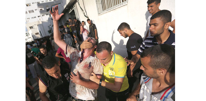 A relative of one of 17 Palestinians killed after an Israeli strike on a market crying in Shejaiya neighbourhood near Gaza City yesterday.