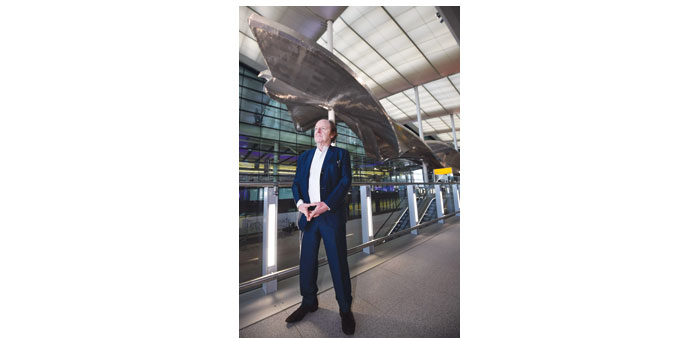 Artist Richard Wilson poses for photographers with his sculpture entitled u2018Slipstreamu2019 in the new Terminal Two at Heathrow Airport yesterday.
