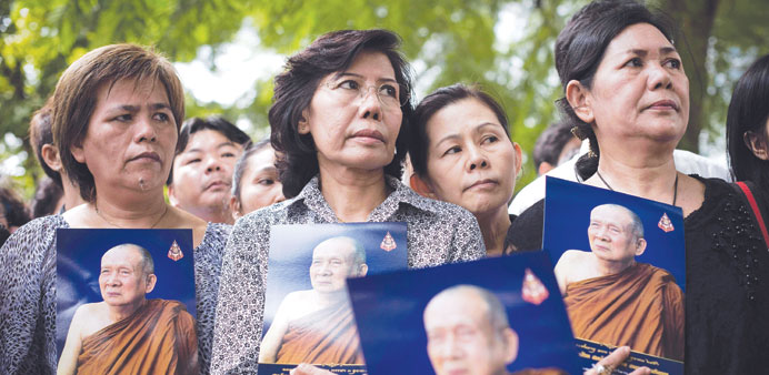 Thai women hold a portrait of Supreme Patriarch Somdet Phra Nyanasamvara outside the Chulalongkorn hospital, in Bangkok yesterday