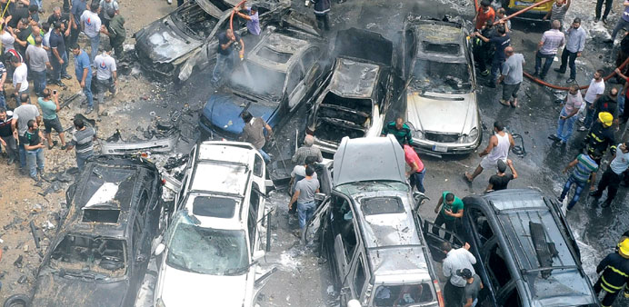 Firefighters and residents gather at the site of the explosion in the Bir al-Abed area of Beirutu2019s southern suburbs yesterday.