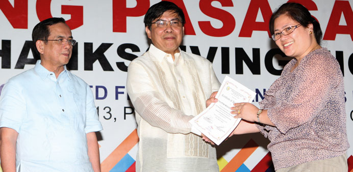 Ambassador Relacion presenting an award as Labour attache Leopoldo De Jesus looks on.
