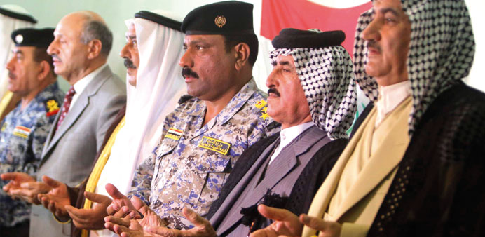Members of Iraqu2019s military pray alongside Sunni tribesmen during a meeting on August 20 on the outskirts of Baghdad.