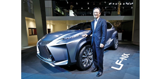  Tokuo Fukuichi, executive vice president of Lexus, poses next to a Lexus LF-NX mid-size crossover concept car during a media preview day at the Frank