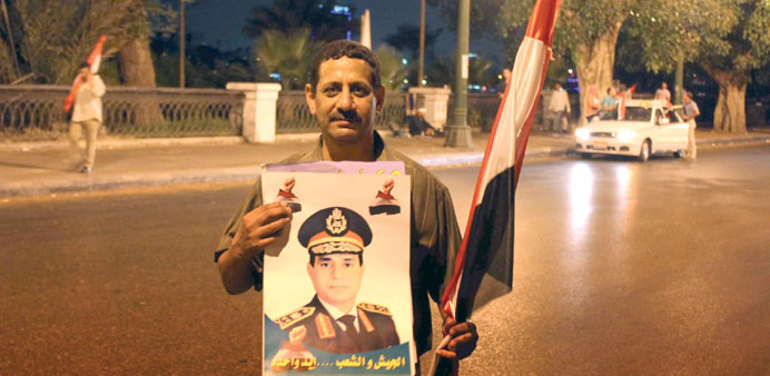 A man posing with a photograph of Egyptian Defence Minister Abdel Fattah al-Sissi in Cairo yesterday.