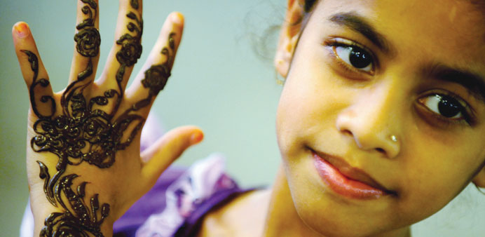 A young girl shows off her henna-decorated hand yesterday at Souq Waqif during the preparations for Eid al-Adha. PICTURE: Jayan Orma