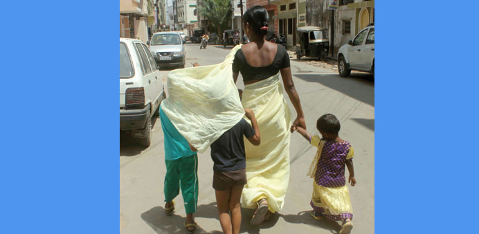  A woman protects her children on a scorching day in Hyderabad yesterday.
