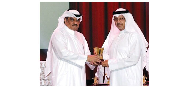 Abdulla Saleh al-Raisi receiving a memento on behalf of Commercial Bank.