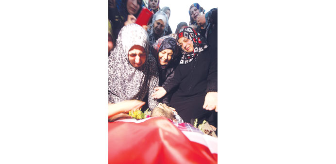   Relatives and friends mourn over the body of Palestinian Anas al-Atrash, 23, after he was killed by Israeli soldiers at a checkpoint near Jerusalem,