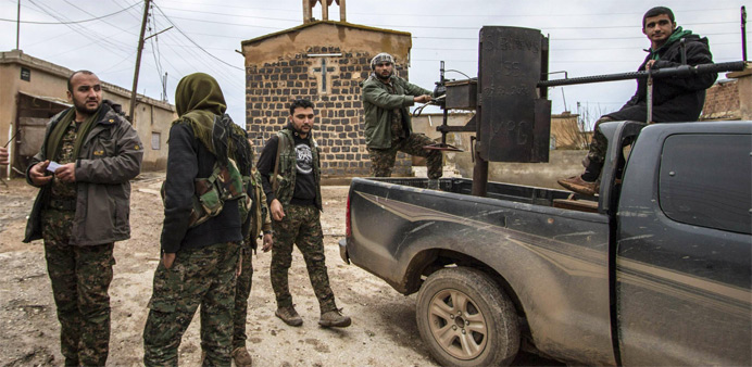 Fighters of the Kurdish People's Protection Units (YPG) stand near a pick-up truck mounted with an anti-aircraft weapon