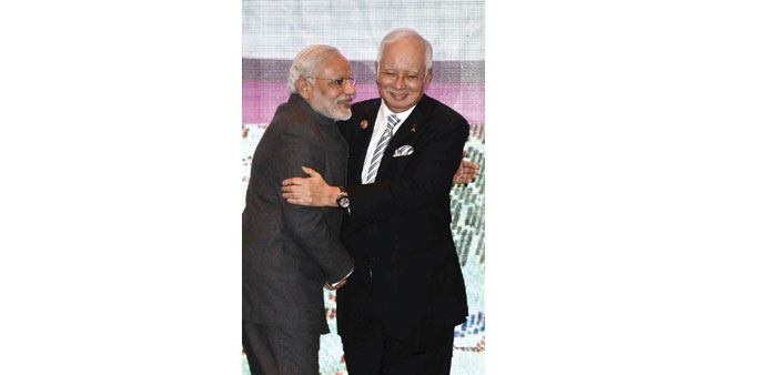 Prime Minister Narendra Modi and his Malaysian counterpart Najib Razak embrace as they take part in a group photo during the Asean- India meeting, par