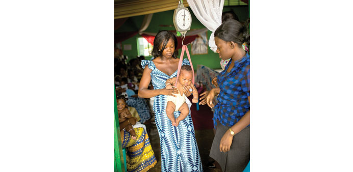 Women weighing an infant at a health facility in Accra.