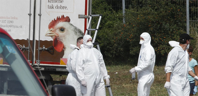 Forensic officers work at a truck inside which were found a large number of dead migrants on a motorway near Neusiedl am See, Austria