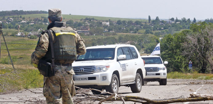 OSCE vehicles enter the village of Shyrokyne, in the Donetsk region, on Saturday.