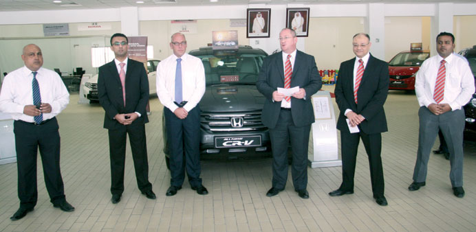 Roffey (third right) speaks as other Domasco officials look on at the new showroom of Honda on Salwa Road.