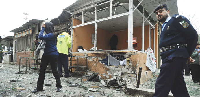 Pakistani security officials inspect the scene of suicide bomb attack that targeted the local court in Islamabad  yesterday.
