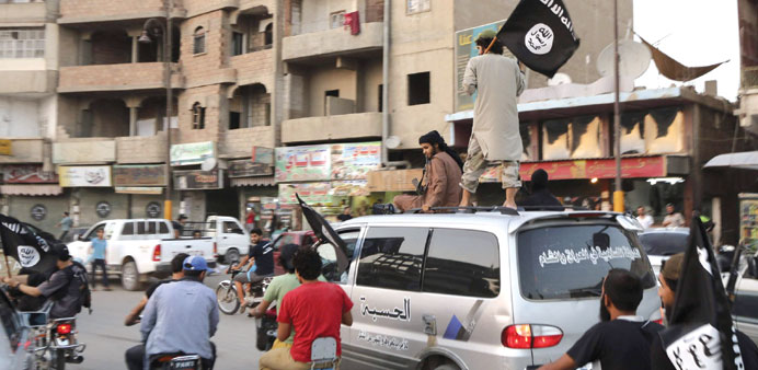 Members of the Islamic State of Iraq and the Levant wave ISIL flags as they drive around Raqa yesterday.