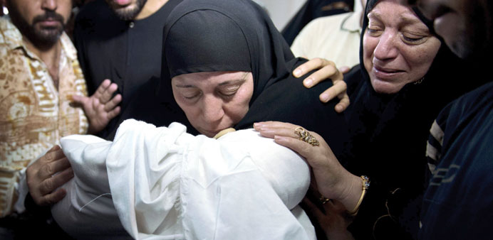 Relatives of seven-month-old Ali Deif, the son of Hamasu2019s military commander Mohamed Deif, hold his body as they mourn during the funeral of the child