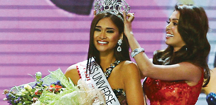 2014 Binibining Pilipinas Universe M J Lastimosa (right) adjusts the crown, she relinquished to Pia Wurtzbach, who won the title after two previously 