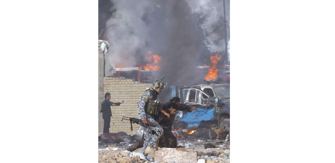 An injured man is evacuated from the scene of the bombings at the rally in Baghdad yesterday.