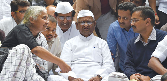 Delhi Chief Mnister Arvind Kejriwal talks with anti-corruption activist Anna Hazare and activist Medha Patkar during a protest rally in New Delhi yest