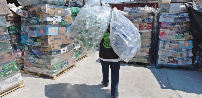 Maria Angelica carries bags of empty bottles at u201cSure We Canu201d redemption centre in New York.