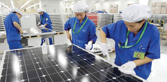 Employees work on solar panels at a factory in Hangzhou, Zhejiang province of China.