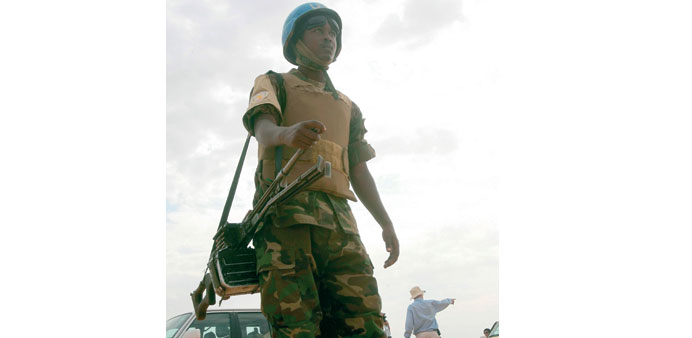 A file picture taken on October 18, 2012, shows a UNAMID soldier standing guard at a camp for internally displaced persons in El Fasher, North Darfur