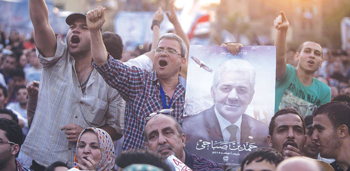 Supporters of presidential candidate Hamdeen Sabbahi (portrait) shout slogans during a campaign rally in Cairo yesterday
