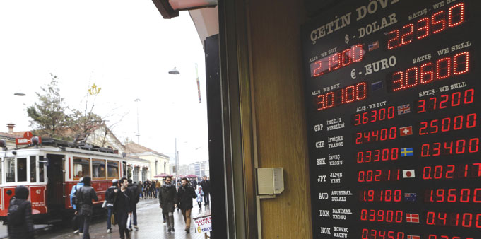 Foreign currency exchange rates are displayed on a screen outside an exchange office in central Istanbul. Turkish Finance Minister Mehmet Simsek playe