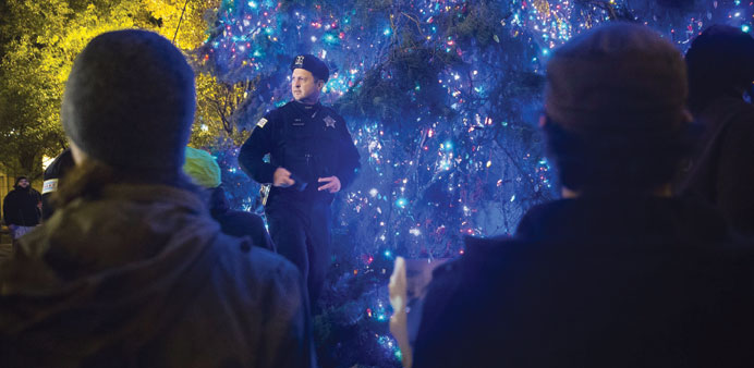 Police guard the city Christmas tree after protesters started to rip lights off of it, on Wednesday evening in Chicago.