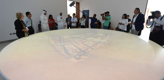Ali shows to journalists how the interactive media dish at Mohamed Bin Jassim House works. 