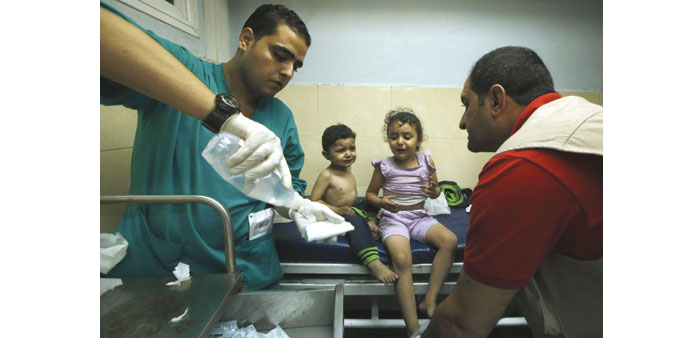 Palestinian children, who were wounded in an Israeli air strike, receiving treatment at a hospital in Gaza City yesterday.
