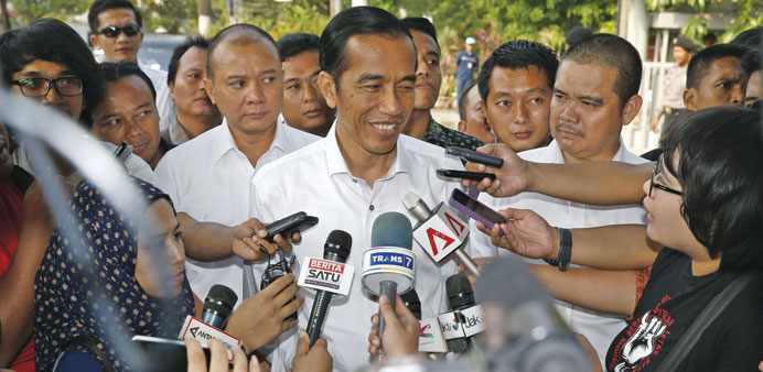 Presidential candidate Joko Widodo (centre) speaks to reporters at the Bisnis Indonesia newspaper office in Jakarta yesterday.