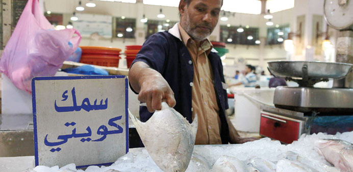 A vendor holds a pomfret at the main fish market in Kuwait City.