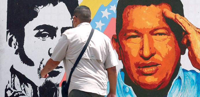 A man walking past a mural portraying the Venezuelan flag, President Hugo Chavez and South American liberator Simon Bolivar at the 23 de Enero neighbo
